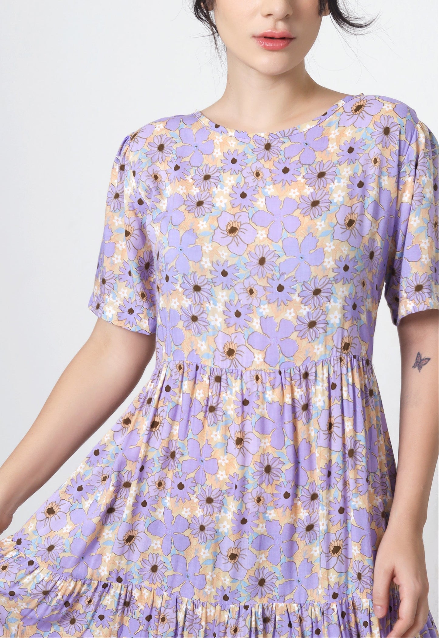 Woman wearing a purple floral dress on a white background