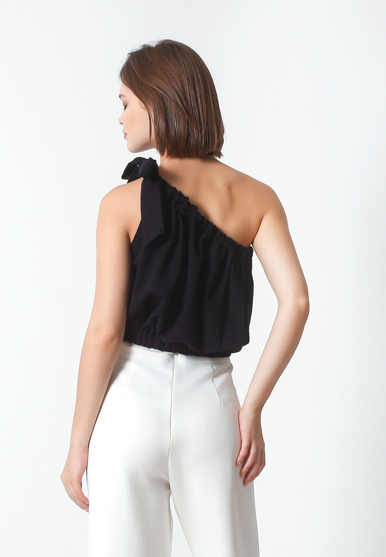 Chic and Trendy Design: Featuring a stylish one-shoulder silhouette and a playful tie detail on the shoulder, this crop top exudes contemporary charm and effortless elegance. Flattering Fit: The elasticized waistband ensures a comfortable and customized fit, while accentuating your curves for a flattering look. Versatile Styling: Whether paired with high-waisted jeans for a casual daytime look or dressed up with a skirt for a night out, this crop top offers endless styling possibilities for any occasion.